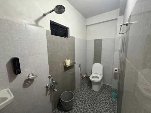 a bathroom with a toilet and a sink at Cloud Valley Inn in Cherrapunji