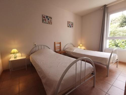 two beds in a room with a window at Lou soula in Trilla