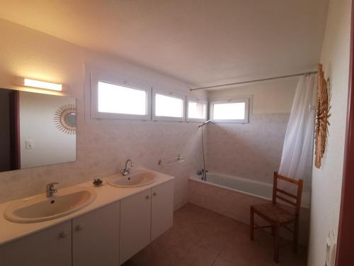 a bathroom with two sinks and a tub and a mirror at Lou soula in Trilla