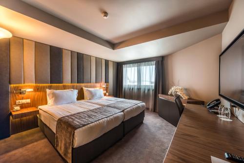 a hotel room with a bed and a television at All Seasons Residence Design Hotel - Free parking in Sofia