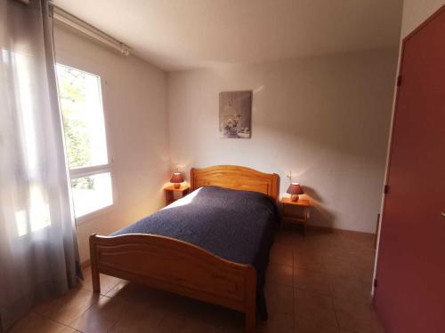 a bedroom with a wooden bed and a window at Rouvenac in Trilla