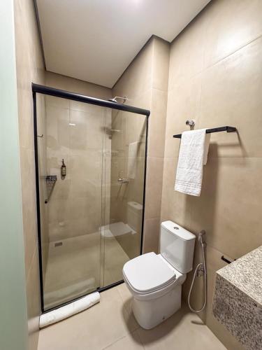 a bathroom with a shower and a white toilet at Uai Hotel Jaíba in Terra Fôfa