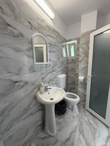 a bathroom with a sink and a toilet and a mirror at Casa Raul Eforie Sud in Eforie Sud