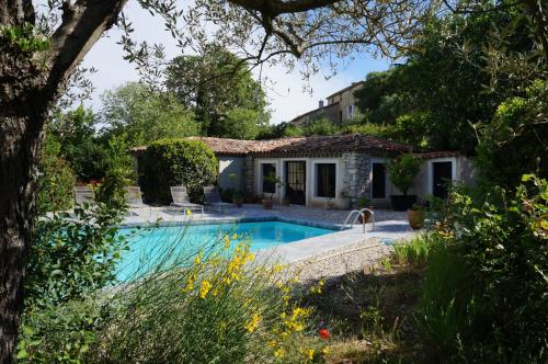 une maison avec une piscine dans un jardin dans l'établissement La Santoline, à Beaulieu