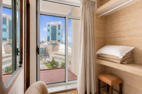 a room with a window with a bed and a pillow at Hotel Vice-Rei in Porto