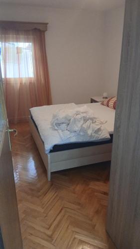 a bedroom with a bed with white sheets and a window at Stan in Bar