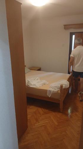 a man standing next to a bed in a room at Stan in Bar