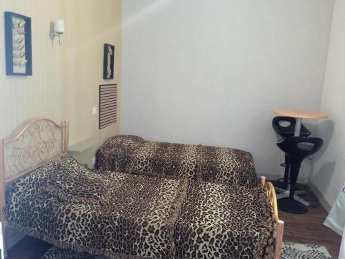 a bedroom with a leopard print bed and a table at Joli hébergement indépendant in Lavelanet