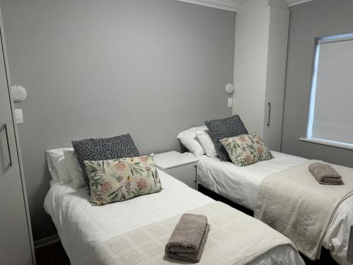 a room with two beds with towels on them at Arbeidsgenot, Unit 2 in Herolds Bay