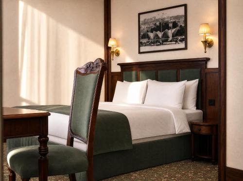 a bedroom with a bed and a desk and a chair at Midway Park Hotel in Baku