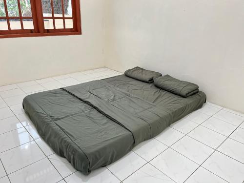 a bed sitting on a tiled floor in a room at Villa Kay Terrace in Campaka
