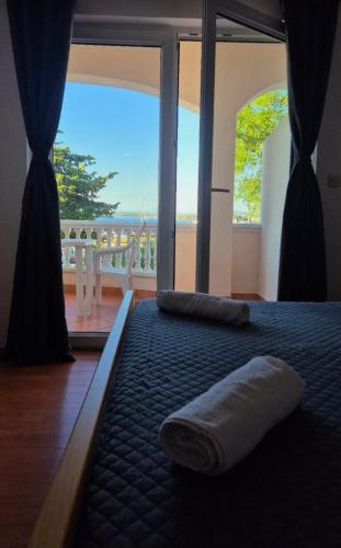 a bed with a towel on it in front of a window at Villa Andale Suites in Tkon