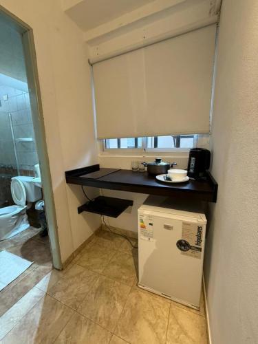 a small kitchen with a counter and a refrigerator at Hotel Diamante in Resistencia
