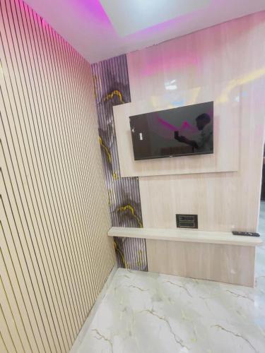 a room with a tv on a wall at Radhika Cozy Studio Apartment Kitchen 2 Double Beds in Vrindāvan