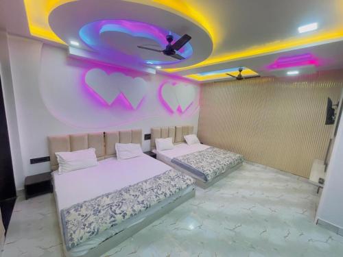 two beds in a room with hearts painted on the wall at Radhika Cozy Studio Apartment Kitchen 2 Double Beds in Vrindāvan