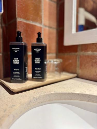 two bottles ofodorizers sitting on a shelf above a sink at Herdade Da Corte in Tavira