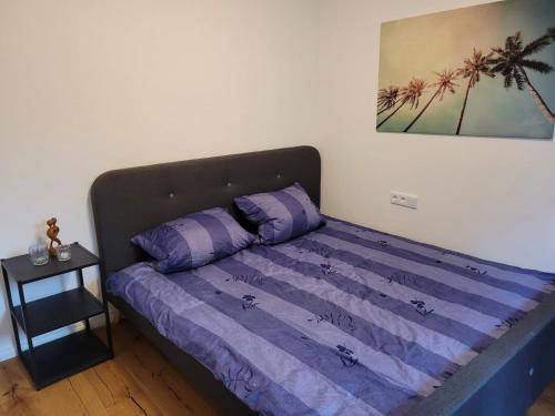 a bed in a room with a purple comforter at Neues 2 Zimmer Schmuckstück in Ergetsweiler