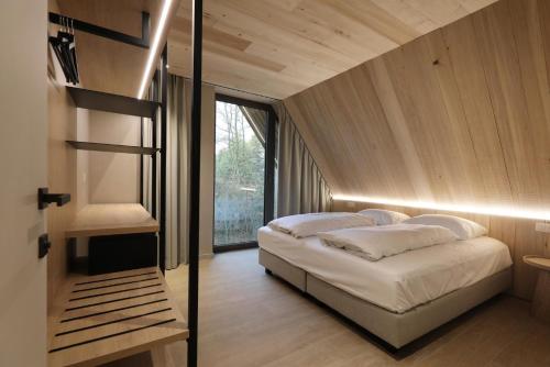 a bedroom with a bed and a large window at Luxury Lodge with Jacuzzi for 8 – Woodz Lodges in Heusden - Zolder