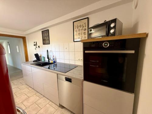 a kitchen with a stove and a microwave at Weserglück Ferienwohnung Grohnde in Emmerthal