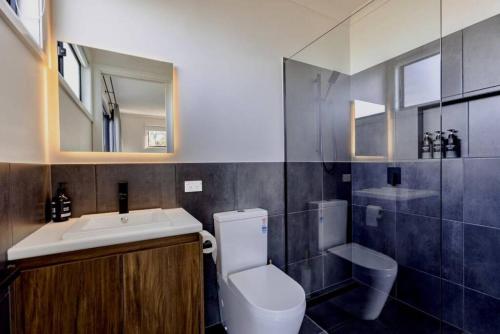 a bathroom with a toilet and a sink and a mirror at Boutique Room - Wamoon Retreat in Yanakie