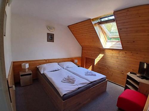 a small bedroom with a bed with a window at Penzion Čistá in Černý Dŭl