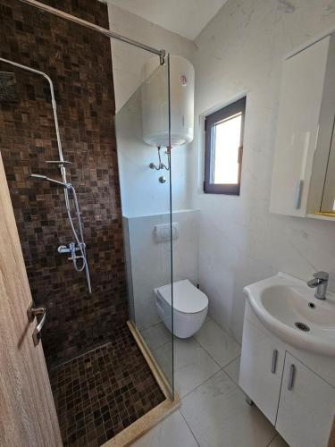 a bathroom with a shower and a toilet and a sink at Beachfront Blue Panorama in Bar
