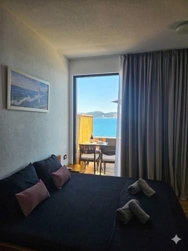 a bedroom with a bed and a view of the ocean at Beachfront Blue Panorama in Bar