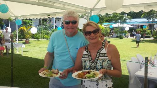 a man and a woman holding plates of food at Rapopo Plantation Resort in Kokopo