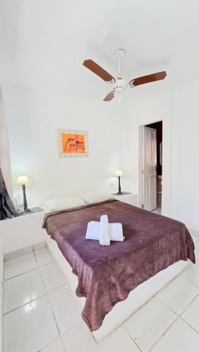 a white bedroom with a large bed with two pillows at Bella vida Geriba suites in Búzios