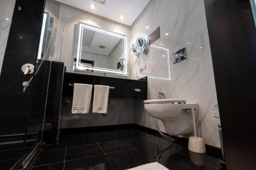 a bathroom with a white toilet and a mirror at فندق الراحة السويسرية Swiss Repose Hotel in Jeddah