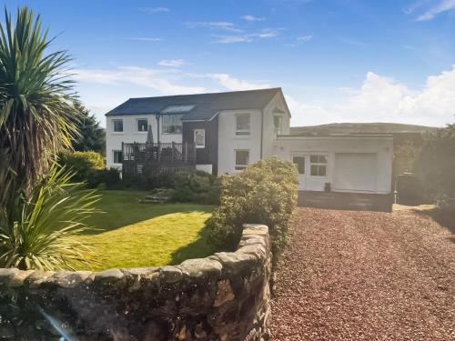 a house with a stone fence in front of it at Hollinhaven in Blackwaterfoot