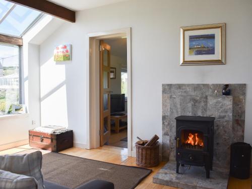 a living room with a fireplace and a couch at Hollinhaven in Blackwaterfoot
