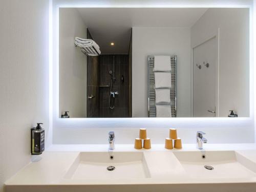 a bathroom with a sink and a large mirror at ibis Paris Canal Saint Martin in Paris
