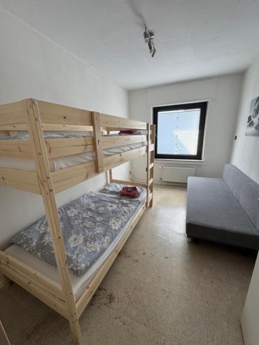 a bedroom with two bunk beds and a couch at Fewo Tanja in Bestwig