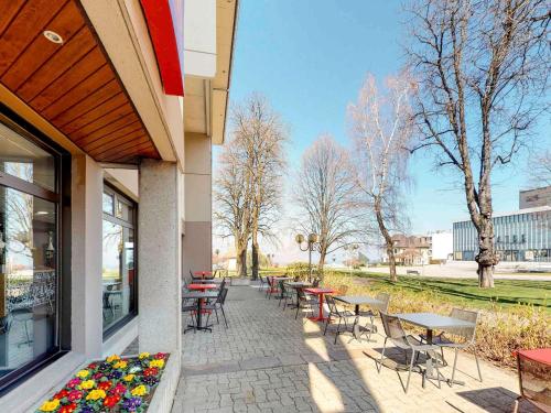 a patio with tables and chairs next to a building at ibis Thonon Centre in Thonon-les-Bains