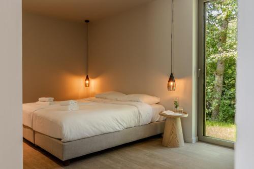 a bedroom with a large bed and a window at Accessible Luxury Suite for 2 – Woodz Lodges in Heusden - Zolder