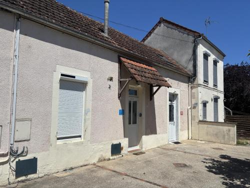 a small white building with a door and a window at L’escale féerique in Auxerre