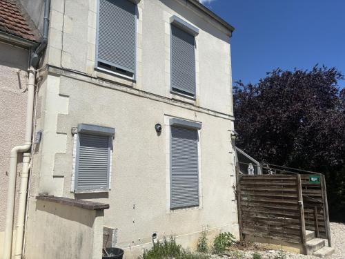 a building with shutters on the side of it at L’escale féerique in Auxerre