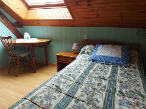 a bedroom with a bed and a desk and a table at Chambres vertes in Bouchamps-lès-Craon