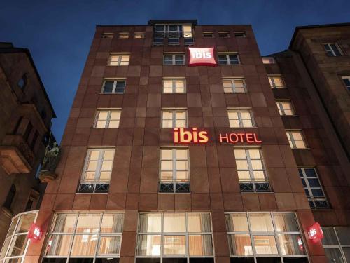 a tall building with a bus hotel sign on it at ibis Hotel Nürnberg Altstadt in Nuremberg