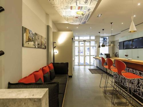 a living room with a bar and some chairs at ibis Hotel Nürnberg Altstadt in Nuremberg