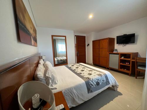 a bedroom with a bed and a dresser and a television at Hotel Atrium Plaza in Barranquilla