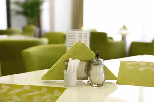 a table with a green napkin and a container on it at Arka Rooms&Apartments in Budva