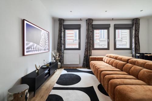 a living room with a couch and a television at MM Suites Town House Terrasse in Reims