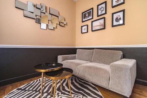 a living room with a couch and a table at MM Suites Reims Centre Terasse in Reims