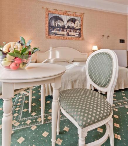 a table and two chairs with a bowl of fruit on it at Hotel Terme Roma in Abano Terme