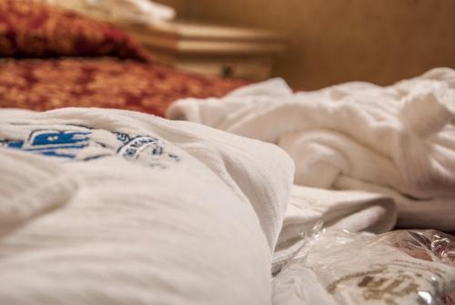 a pile of white sheets on a bed at Hotel Terme Roma in Abano Terme