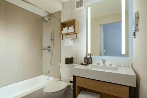a bathroom with a toilet and a sink and a tub at Sheraton Philadelphia University City Hotel in Philadelphia
