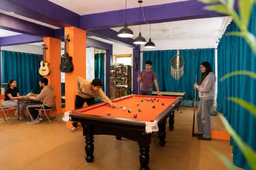 a group of people playing pool in a room at Loopin Mcleodganj in McLeod Ganj