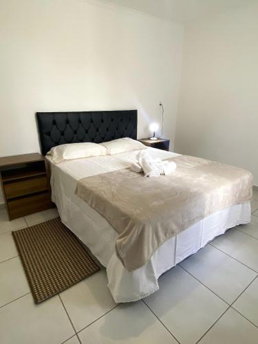 a bedroom with a large bed with a black headboard at RCM Vilas - Casa Confortável 02 in Joinville